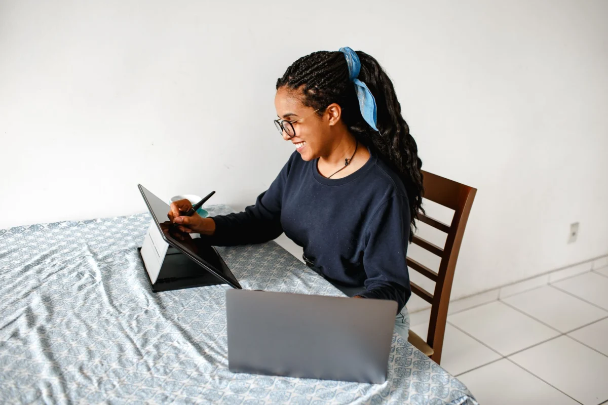 Pessoa em uma escrivaninha de casa conversando atentamente pelo notebook via vídeo